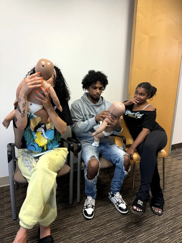 Students practicing infant choking relief on training manikins